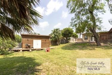 view of yard featuring a deck and a storage unit