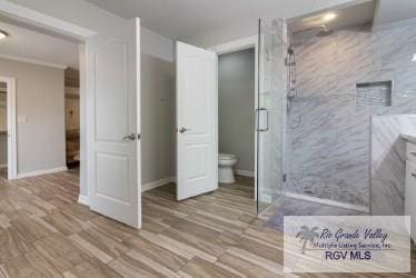 bathroom with hardwood / wood-style flooring, toilet, and walk in shower