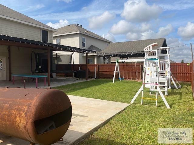 view of yard featuring a playground, a patio, and a trampoline