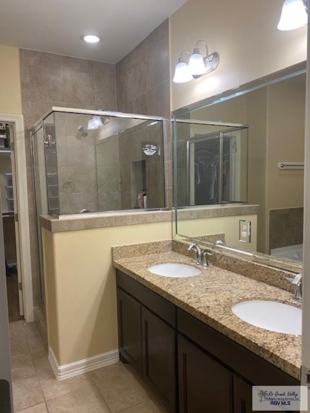 bathroom featuring tile patterned flooring, vanity, and walk in shower