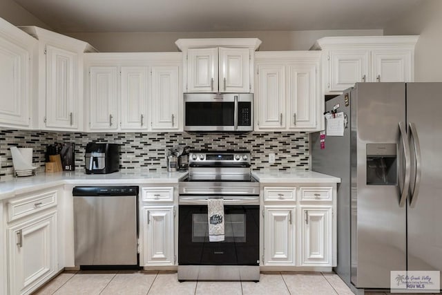 kitchen with light countertops, light tile patterned flooring, tasteful backsplash, and appliances with stainless steel finishes