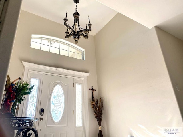 foyer entrance with a chandelier and a high ceiling