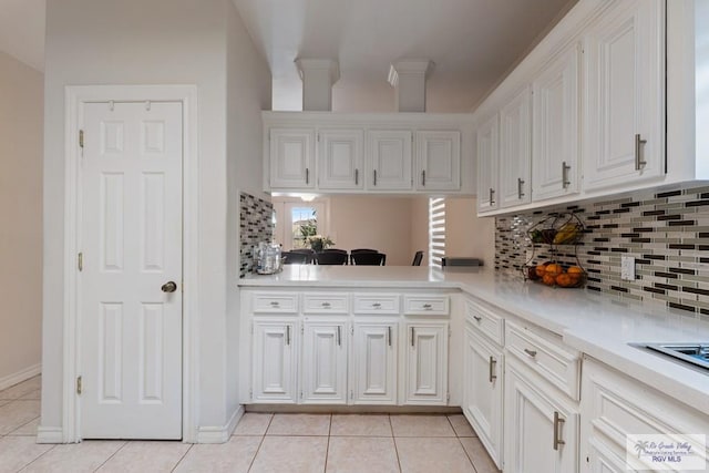 kitchen featuring light tile patterned flooring, white cabinetry, light countertops, and tasteful backsplash