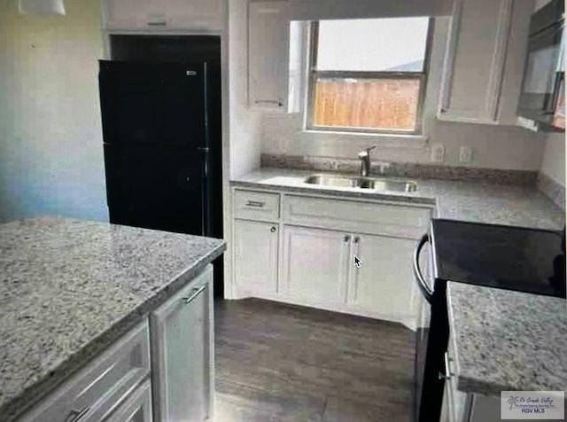 kitchen featuring white cabinetry, light stone countertops, sink, and black appliances