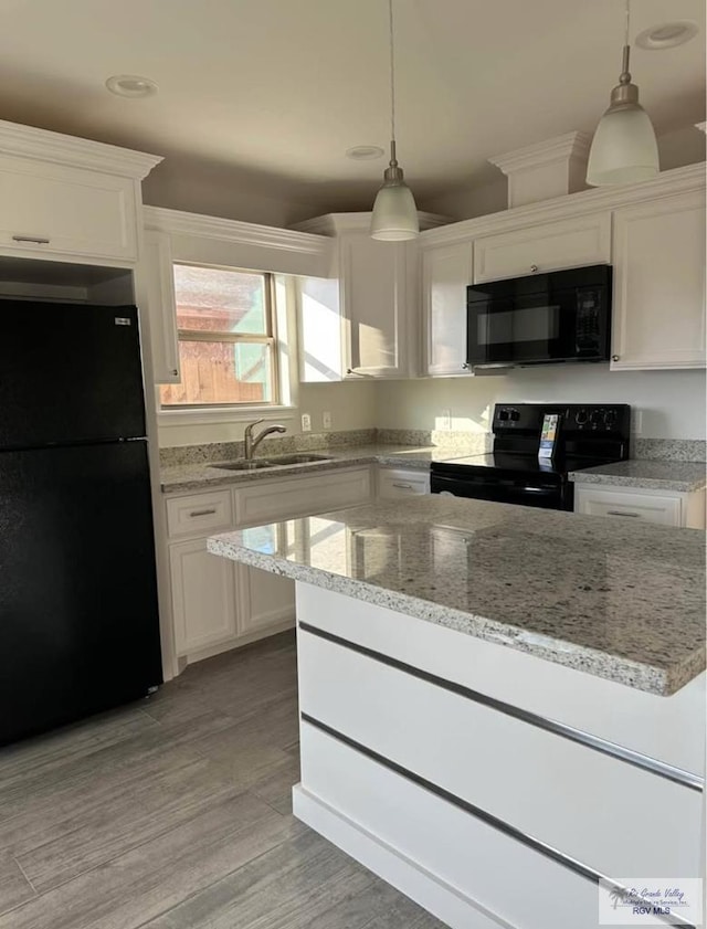 kitchen featuring white cabinetry, decorative light fixtures, sink, and black appliances