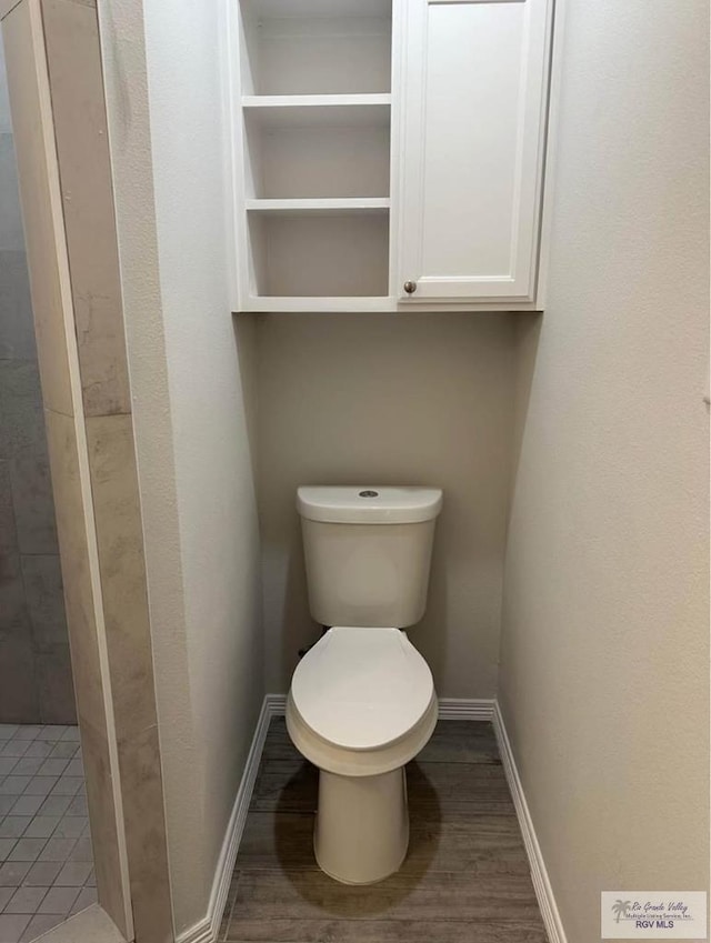 bathroom featuring hardwood / wood-style flooring and toilet