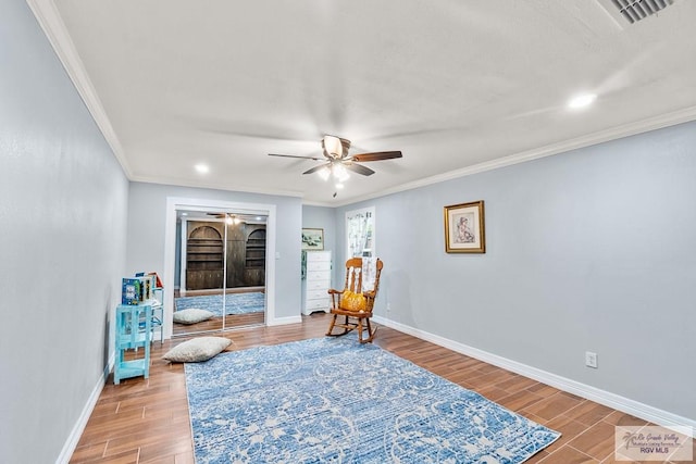 sitting room with visible vents, crown molding, baseboards, and wood finished floors