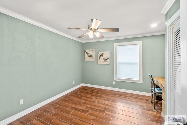 spare room featuring ornamental molding, a ceiling fan, baseboards, and wood tiled floor