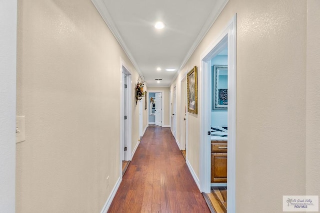 corridor with baseboards, ornamental molding, and dark wood-style flooring