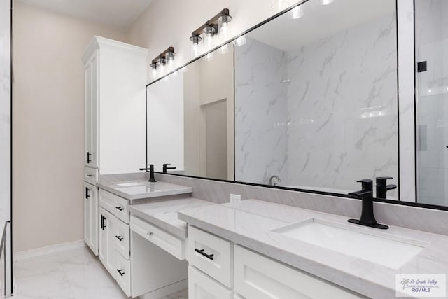 bathroom featuring marble finish floor, double vanity, a sink, and baseboards