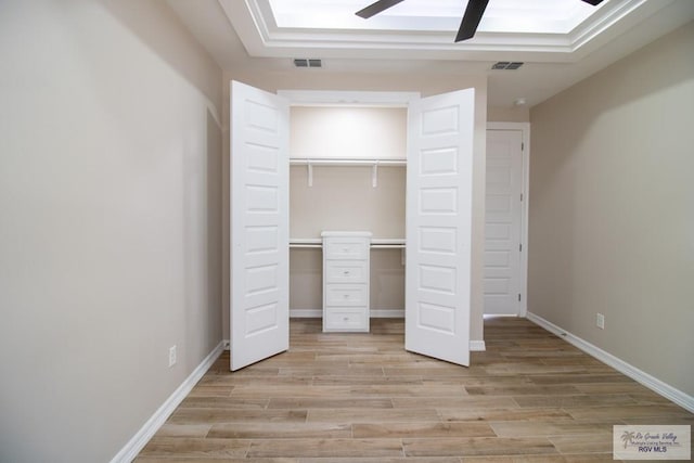 unfurnished bedroom with ceiling fan, a closet, and light hardwood / wood-style flooring