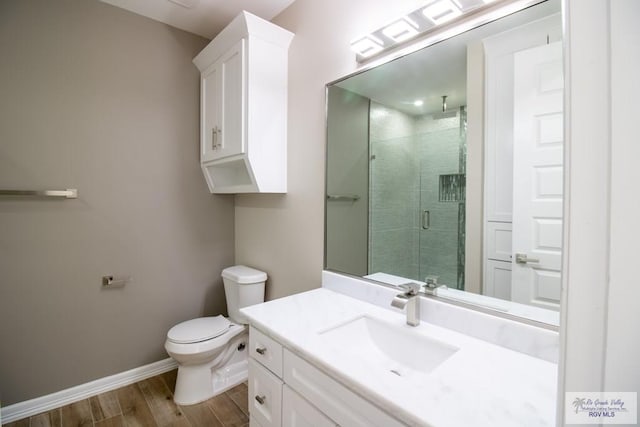 bathroom with walk in shower, toilet, vanity, and hardwood / wood-style flooring