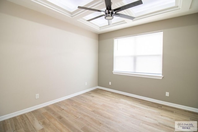 empty room featuring ceiling fan, light hardwood / wood-style floors, and coffered ceiling