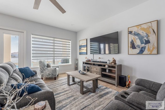 living room featuring wood-type flooring, plenty of natural light, and ceiling fan