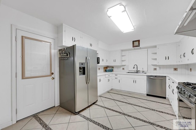 kitchen with sink, stainless steel appliances, tasteful backsplash, white cabinets, and light tile patterned flooring