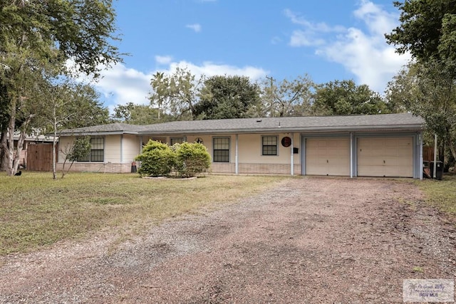 ranch-style home with a garage and a front lawn