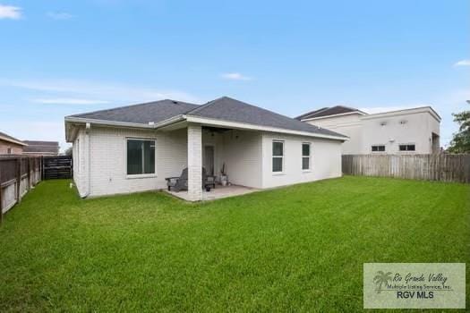 back of property with a lawn and a patio