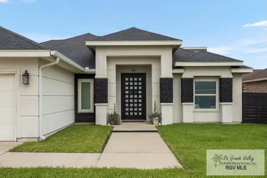 doorway to property featuring a lawn and a garage