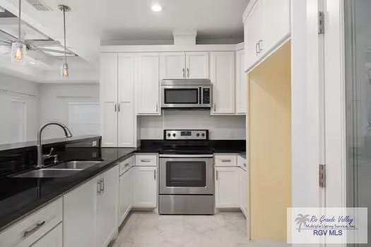 kitchen featuring pendant lighting, sink, white cabinets, and stainless steel appliances