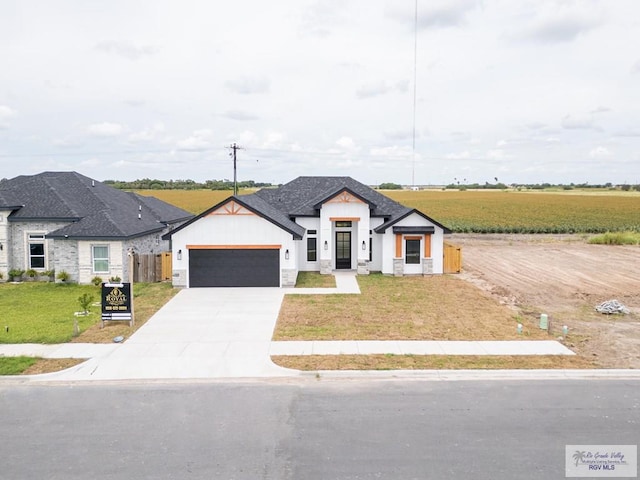 2409 Brown Pelican Ln, Harlingen, TX 78552 - view of front of house with a garage, driveway, and stone siding