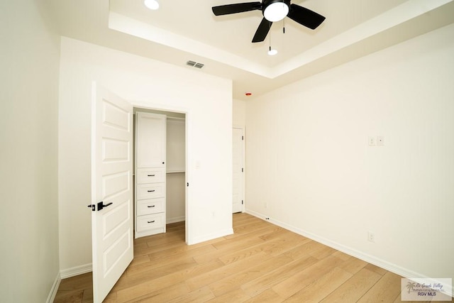 2409 Brown Pelican Ln, Harlingen, TX 78552 - unfurnished bedroom featuring a tray ceiling, light wood-style flooring, recessed lighting, ceiling fan, and a closet