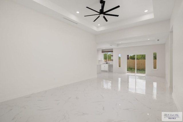 unfurnished room featuring recessed lighting, a raised ceiling, marble finish floor, and a ceiling fan