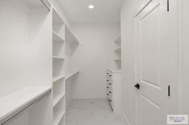 walk in closet featuring marble finish floor