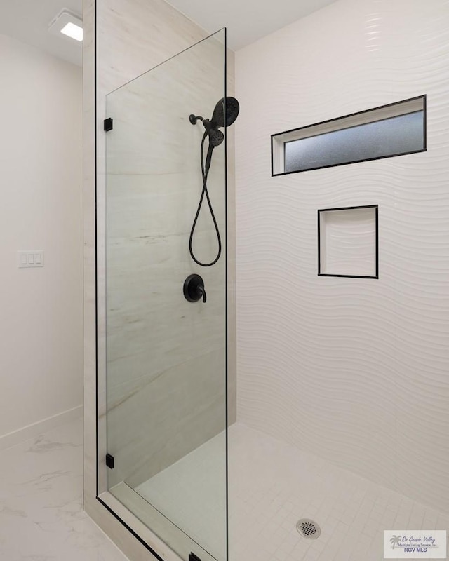 full bath featuring baseboards, marble finish floor, and a shower stall