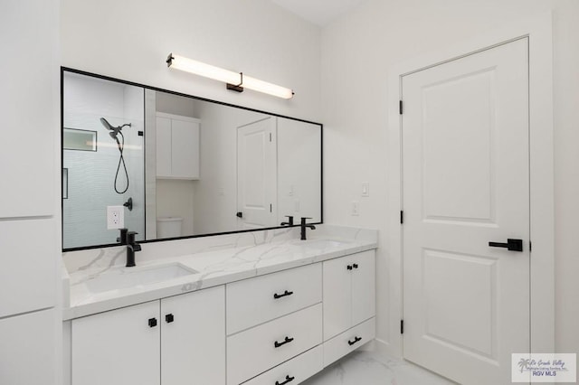 bathroom featuring a sink, toilet, marble finish floor, and walk in shower