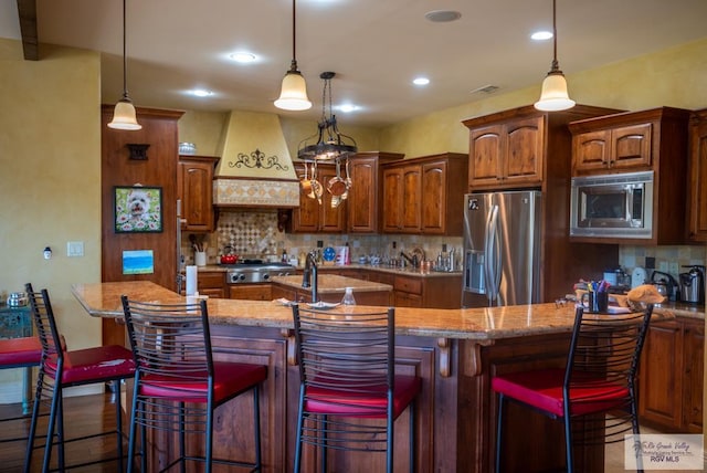 4329 Waters Edge, Harlingen, TX 78550 - kitchen featuring tasteful backsplash, premium range hood, a spacious island, a kitchen bar, and stainless steel appliances