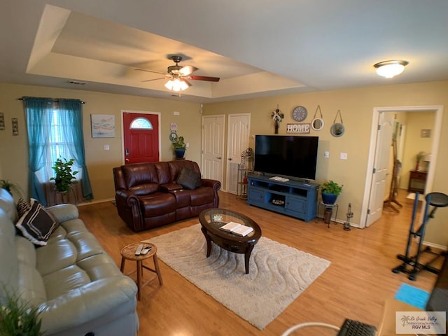 14022 Whitewing Ln, Lyford, TX 78569 - living area featuring a tray ceiling, wood finished floors, baseboards, and a ceiling fan
