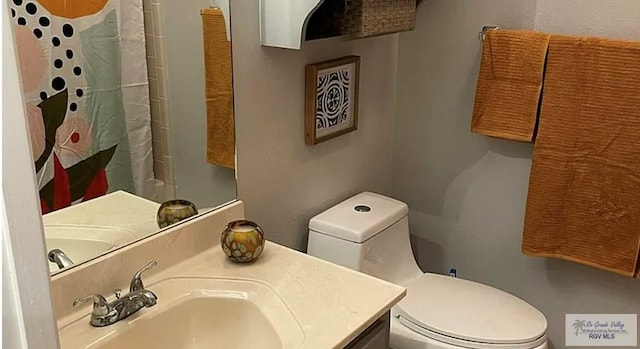 6251 Camelot Dr, Harlingen, TX 78550 - bathroom featuring toilet, a shower with shower curtain, and vanity