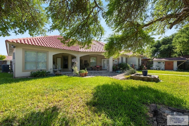 5512 Autumn Mist Ln, Brownsville, TX 78521 - rear view of house with central AC unit, a tile roof, a lawn, stucco siding, and an outdoor structure