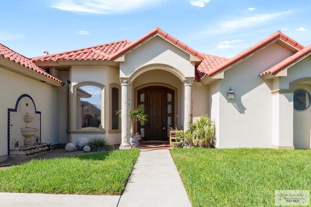 5512 Autumn Mist Ln, Brownsville, TX 78521 - property entrance with a tile roof, a yard, and stucco siding