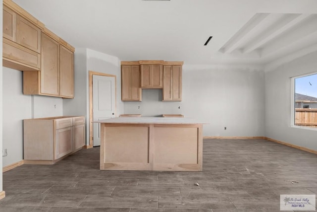 kitchen with a center island, light brown cabinets, baseboards, and wood finished floors