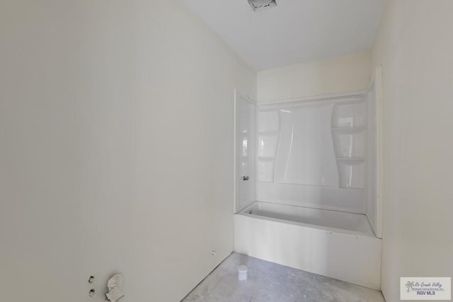 bathroom featuring concrete flooring and a tub to relax in