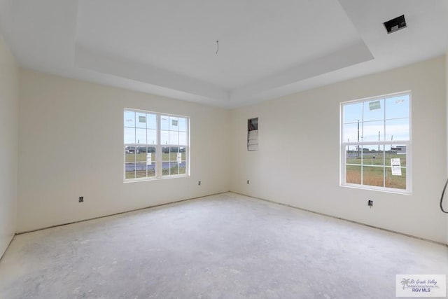 spare room with a tray ceiling