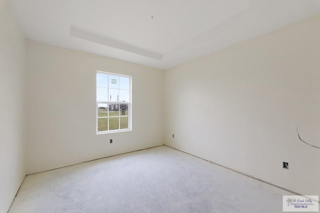 unfurnished room with a tray ceiling