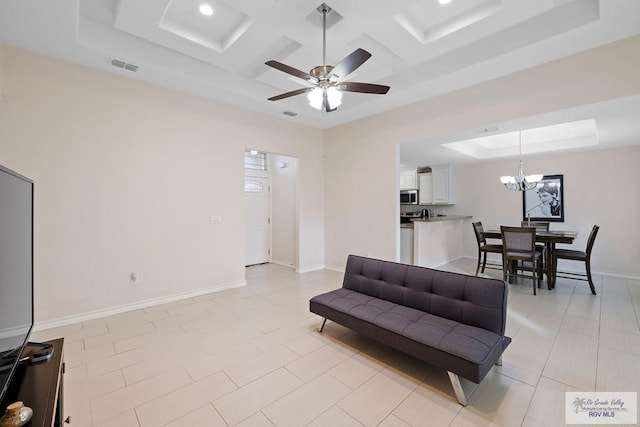 living room with coffered ceiling, light tile patterned floors, ceiling fan with notable chandelier, and a raised ceiling