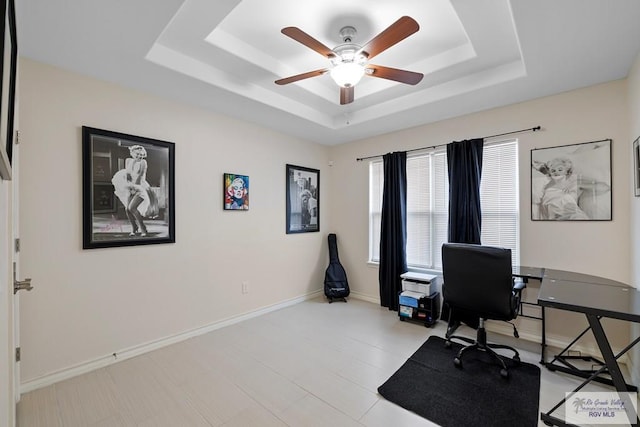 office space featuring ceiling fan and a raised ceiling