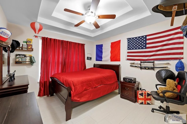 bedroom with a raised ceiling and ceiling fan