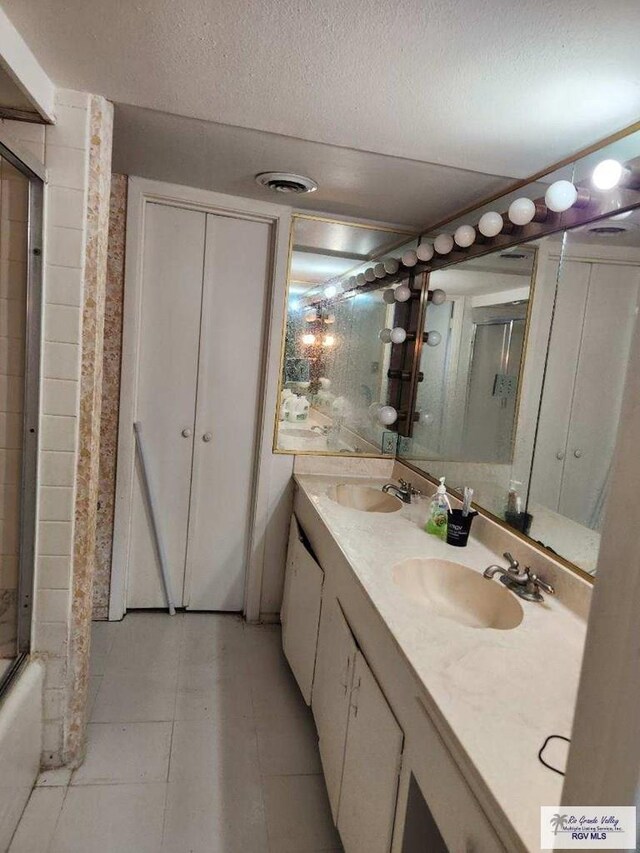 bathroom with shower / washtub combination, a textured ceiling, and vanity