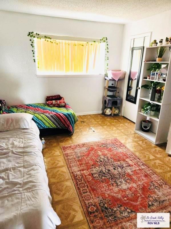 bedroom featuring parquet flooring and a textured ceiling