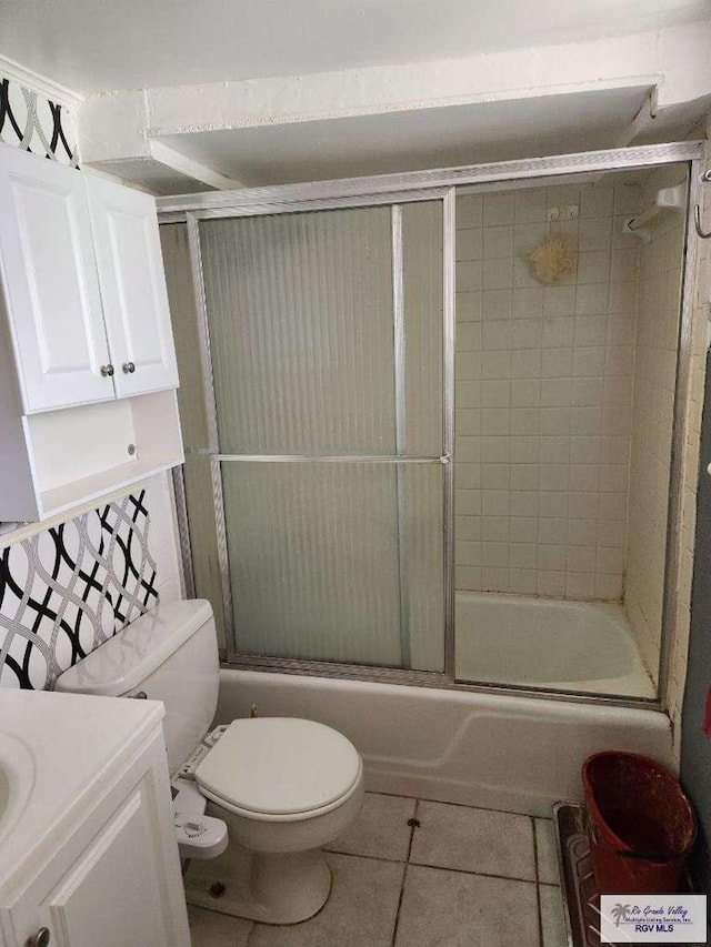 full bathroom featuring enclosed tub / shower combo, vanity, toilet, and tile patterned flooring