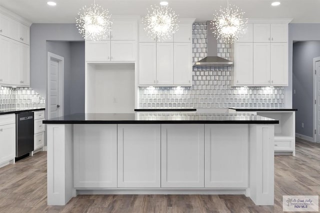 kitchen featuring recessed lighting, an inviting chandelier, tasteful backsplash, white cabinetry, and wall chimney range hood