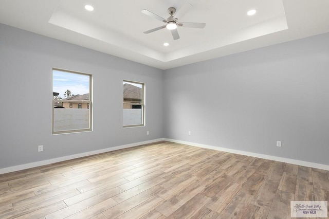 spare room featuring recessed lighting, a raised ceiling, a ceiling fan, and wood finished floors