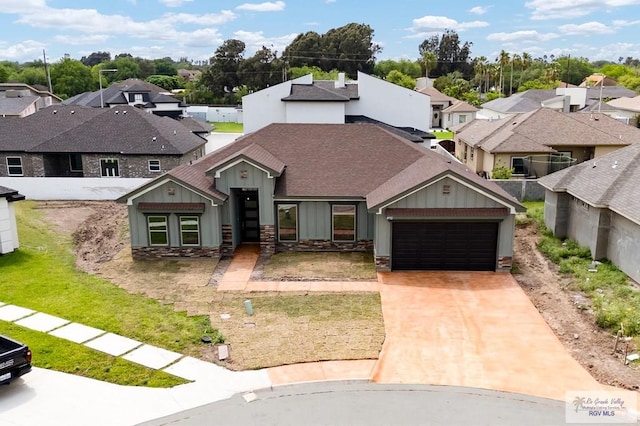view of front of property with a shingled roof, a garage, a residential view, driveway, and board and batten siding