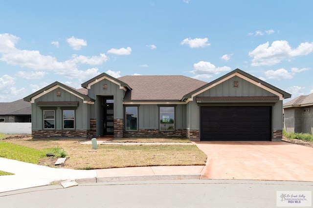 view of front of home featuring a garage, board and batten siding, concrete driveway, and stone siding