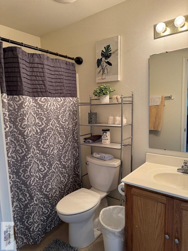 bathroom with vanity, toilet, and a textured ceiling