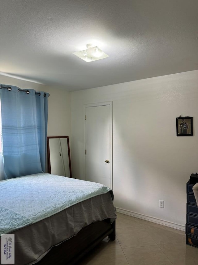 bedroom featuring tile patterned floors and a textured ceiling